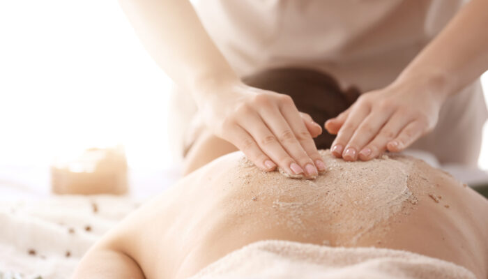 Young,Woman,Undergoing,Treatment,With,Body,Scrub,In,Spa,Salon,